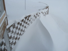 Snow piled to the top of the retining wall